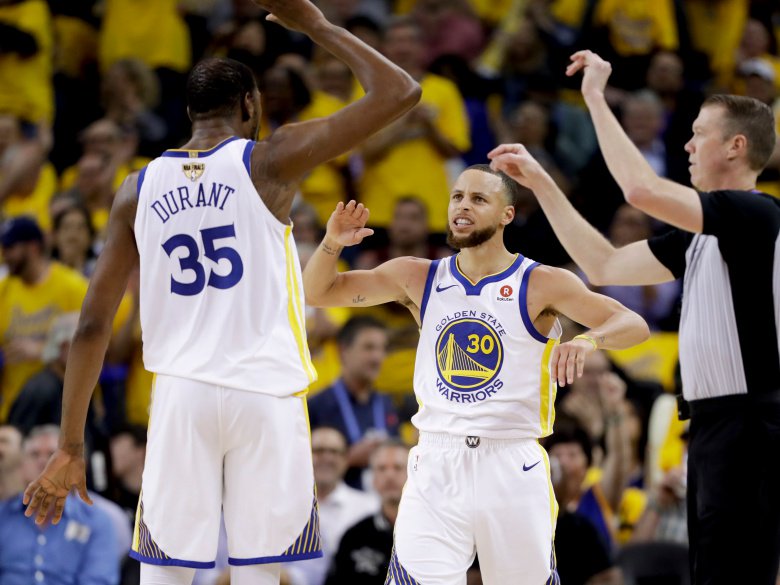 Golden State Warriors forward Kevin Durant (35) celebrates with guard Stephen Curry (30) during the second half of Game 1 of basketball's NBA Finals against the Cleveland Cavaliers in Oakland, Calif., Thursday, May 31, 2018. (AP Photo/Marcio Jose Sanchez)