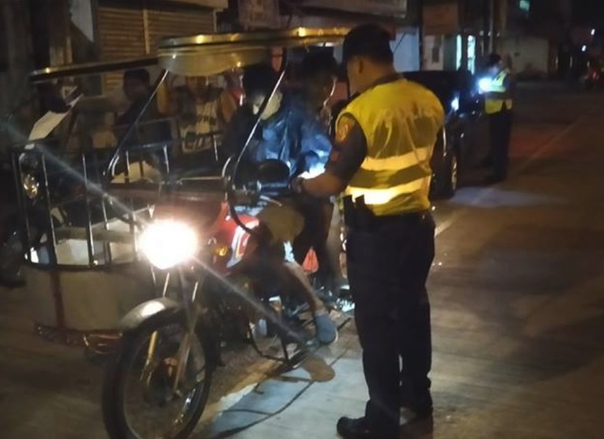 A deputized police officer checks out the idenfication papers from a tricycle driver at a Comelec checkpoint in Calapan City. (Photo credit: Dennis Nebrejo)